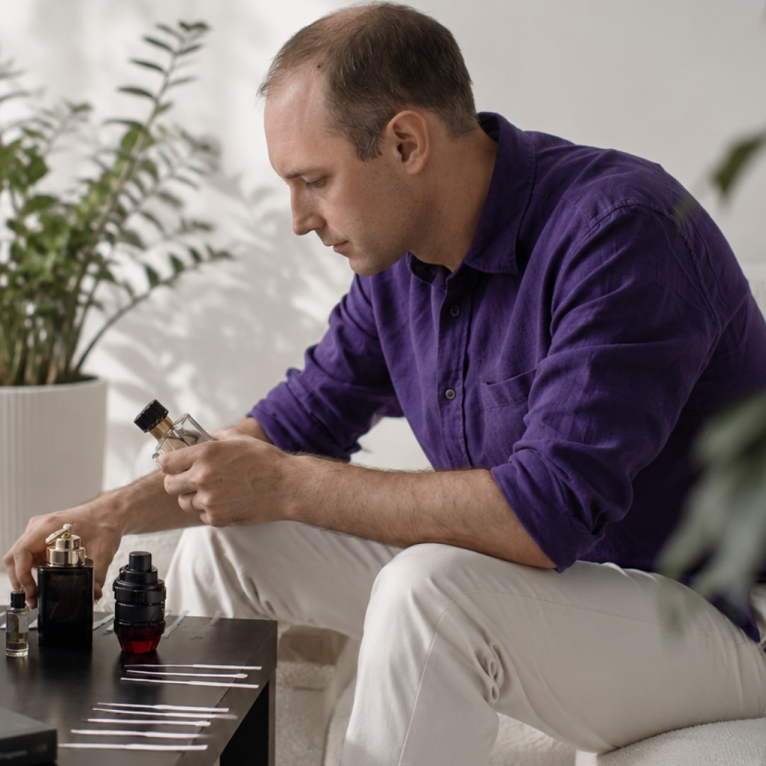 A man comparing men's fragrances at home — exploring scents with MaxManScents